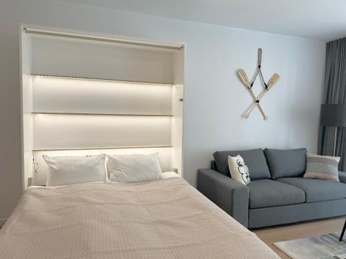 a bedroom with a bed and a couch at Apartamenty Florina Q4Apartments in Łeba