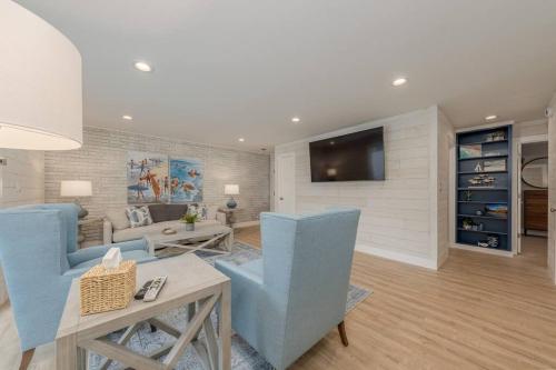 a living room with blue chairs and a tv at Sunset Family Villa C2 in Bridgman