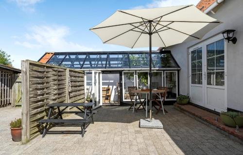 a patio with an umbrella and a table and chairs at Stunning Home In Ulfborg With Wifi in Ulfborg