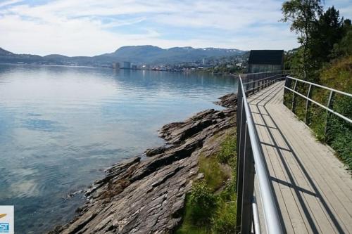 a view of a body of water with a railing at 2 etasje leilighet med 2 soverom in Harstad