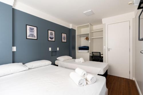 two beds in a room with blue walls at BSB STAY Torre Flats Particulares - Mercure Líder in Brasilia
