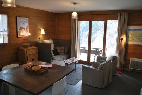 un salon avec une table et des chaises dans l'établissement Le Petit Réconfort, accès skis aux pieds, à Saint-François-Longchamp
