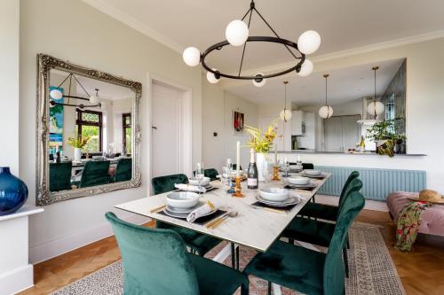 a dining room with a table and chairs and a mirror at The Spinney - Spectacular views over the bay and close to beach with parking in Paignton
