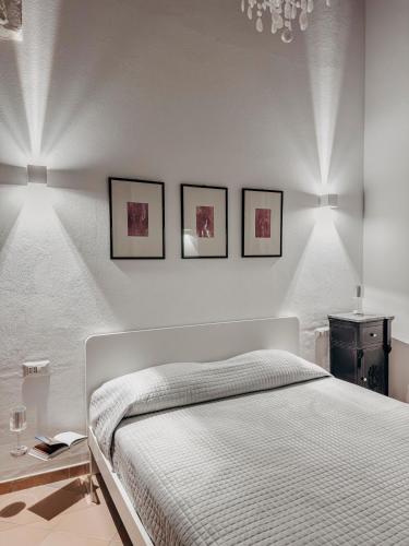 a bedroom with a bed with three pictures on the wall at New Design Ortigia in Syracuse