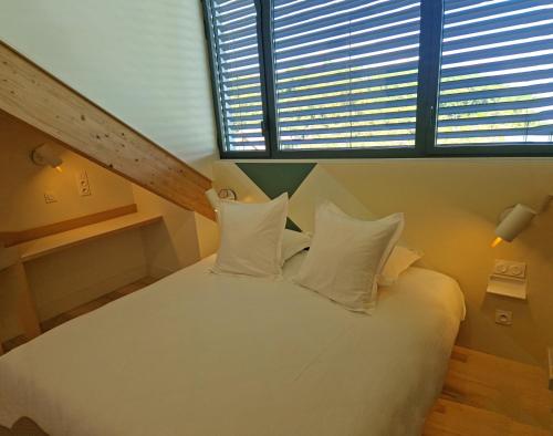 a bedroom with a white bed with a large window at Beau Rivage in Charavines