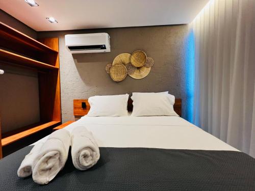 a bedroom with a bed with towels on it at Villa Mutum - Triplex na Rota Ecológica dos Milagres Praia do Patacho in Pôrto de Pedras