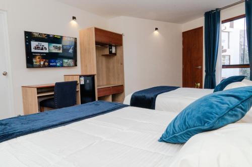 a hotel room with two beds and a tv at Hotel Terra by Refugio Ecológico in Arequipa