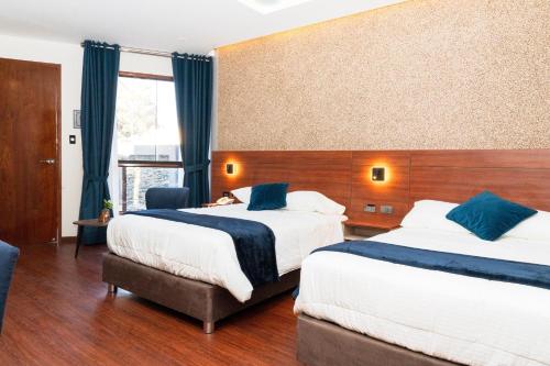 a hotel room with two beds and a window at Hotel Terra by Refugio Ecológico in Arequipa