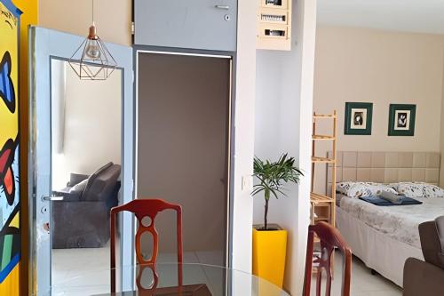 uma sala com uma mesa de vidro e um quarto em Apartamento com ar-condicionado em Salvador