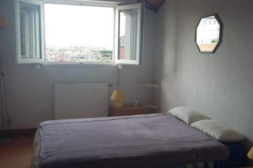 une chambre avec un lit et une grande fenêtre dans l'établissement T2 bis vue mer, 5 pers, grande terrasse, à Anglet