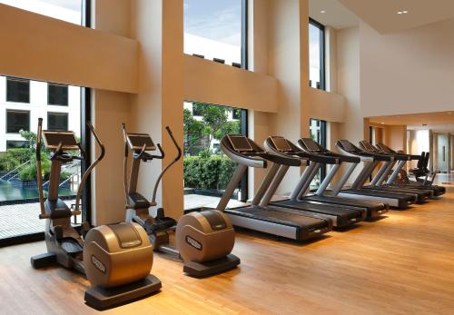 a row of treadmills in a gym with windows at Novotel New Delhi Aerocity- International Airport in New Delhi
