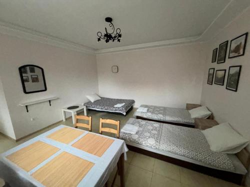 a room with two beds and a table and chairs at Agroturystyka u Darka in Kolno