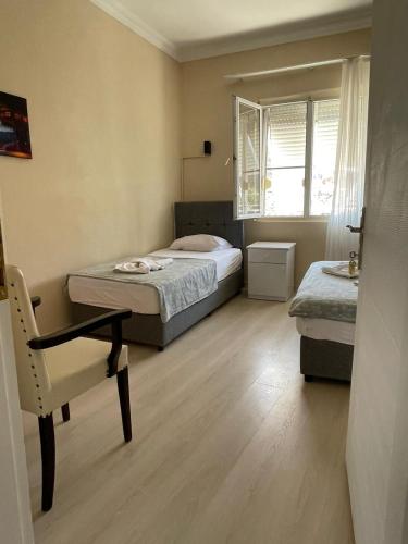 a small bedroom with two beds and a chair at Almina Kantarcı Pansiyon in Ayvalık