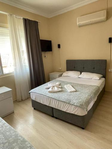 a bedroom with a bed with two towels on it at Almina Kantarcı Pansiyon in Ayvalık
