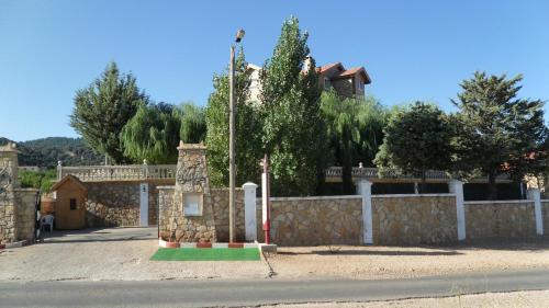 a building with a stone fence and a street at Le Palais des Cerisiers in Azrou