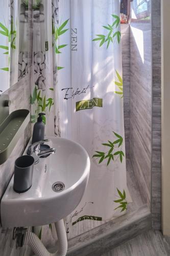 a bathroom with a sink and a shower curtain at Studio Melem 2 in Soko Banja