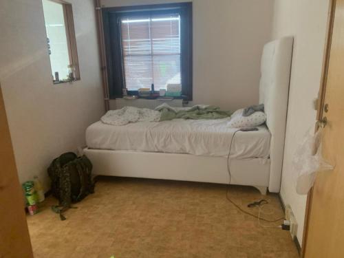 a small bedroom with a bed with a window at Fint hus nära Hörby in Hörby