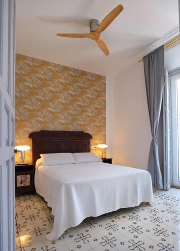 a bedroom with a white bed and a ceiling fan at V11apartamentos1 in Archidona