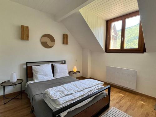une chambre avec un grand lit dans un grenier dans l'établissement Cozy Pyrenees Mountain Retreat, à Castillon-de-Larboust