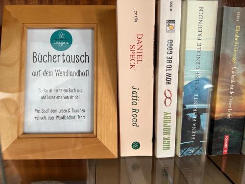 a shelf of books with a sign on it at Wendlandhof Lüggau in Dannenberg