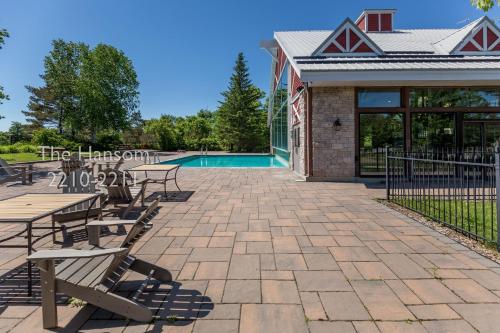 a patio with tables and chairs next to a pool at Country Club Charm - 4-Bed Radiant Resort Condo in Edgar