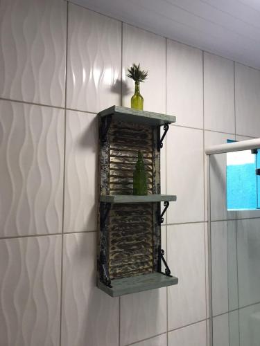 a shelf on a wall with a plant on it at Encanto Chalés – 150m da Praia Grande – Penha – SC in Penha