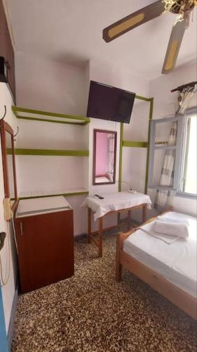 a room with two beds and a table and a mirror at Old town Room With Window in Rethymno