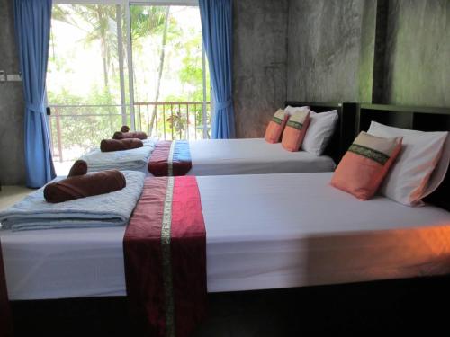 three beds in a room with a window at Real Relax Resort in Ao Nang Beach