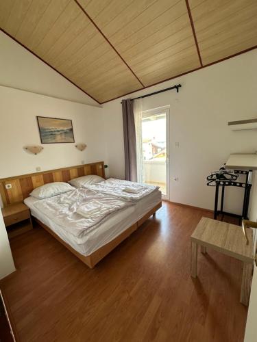 a bedroom with a bed and a wooden floor at Vila Rosa in Tkon
