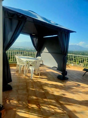 a patio with a table and chairs on a deck at Charmant T2 in Bastelicaccia