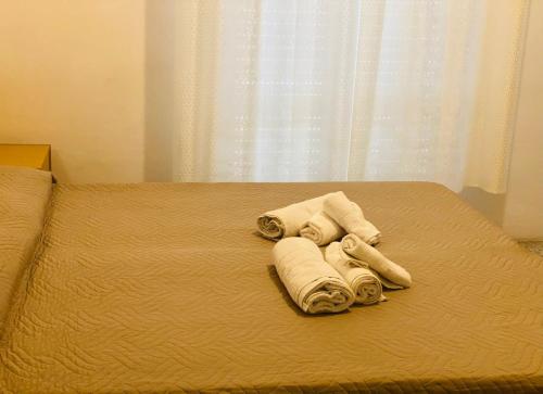 a pile of towels on a bed with a window at hotel iris in Rimini