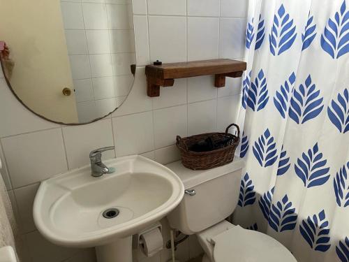 a bathroom with a sink and a toilet and a mirror at Horcon Condominio CAUCAU in Horcón