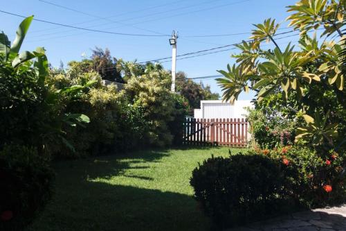een tuin met groen gras en struiken en een hek bij Villa das Pedras - Ponta de Pedras in Goiana