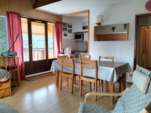 une cuisine et une salle à manger avec une table et des chaises dans l'établissement Charmant T2 à Villard-de-Lans, proche centre, balcon sud, parking privé, idéal pour 4-6 pers. - FR-1-761-20, à Villard-de-Lans