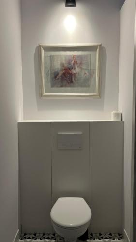 a bathroom with a toilet and a painting on the wall at Art of Sopot in Sopot