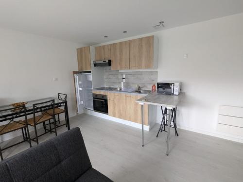 - une cuisine avec un canapé et une table dans une chambre dans l'établissement Au Mouquet, à Parentis-en-Born