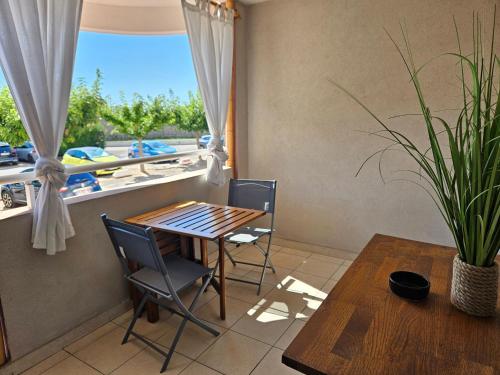 une salle à manger avec une table et des chaises et une fenêtre dans l'établissement Nouveau Entre mer et ville, à Lattes