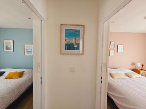 une chambre avec deux lits et un tableau au mur dans l'établissement MAISON de Vacances Entière à 10 mn de La Rochelle, à Dompierre-sur-Mer