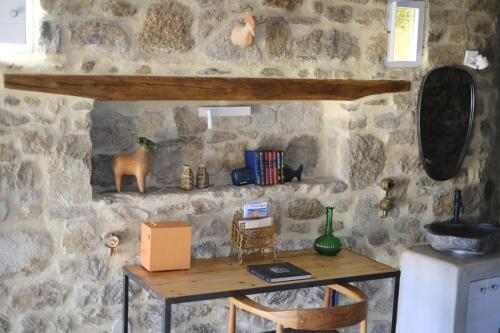 a stone wall with a table in a room at VILLA NAUTILIA - Luxury Suites and Cottages in Kalafatis