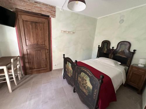 a bedroom with a bed and a wooden door at Nel Caruggio - B&B in Mornese