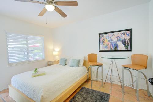 a bedroom with a bed with two chairs and a ceiling fan at Efficiency 2 on water Las Olas, beach and free kayaks in Fort Lauderdale