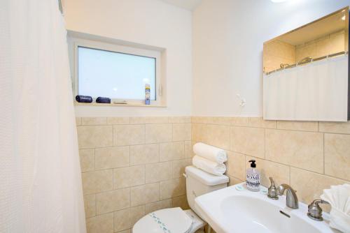 a bathroom with a toilet and a sink and a window at Efficiency 2 on water Las Olas, beach and free kayaks in Fort Lauderdale
