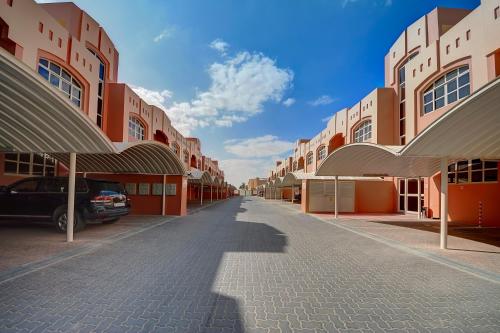a building with a car parked in a parking lot at Asfar Resorts Al Ain in Al Ain