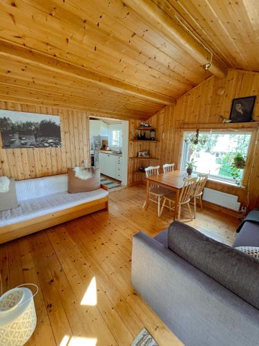 a living room with a couch and a table at Laplandliv cabin on the lake with hottub in Björkliden