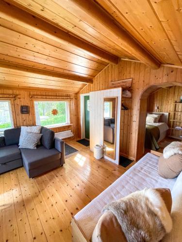 a room with a bed and a couch in a cabin at Laplandliv cabin on the lake with hottub in Björkliden