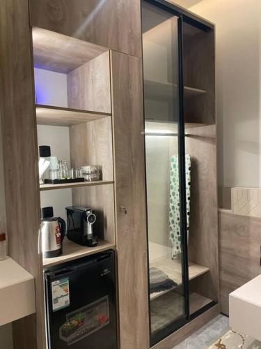 a kitchen with a glass pantry with a appliance at The N&N Executive in Al Madinah