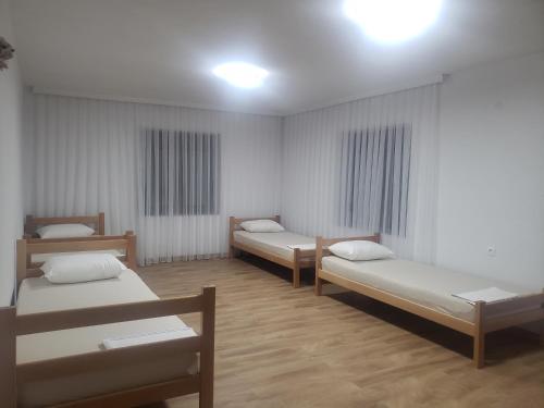 a room with three beds in it at Guest House Vuthaj in Vusanje