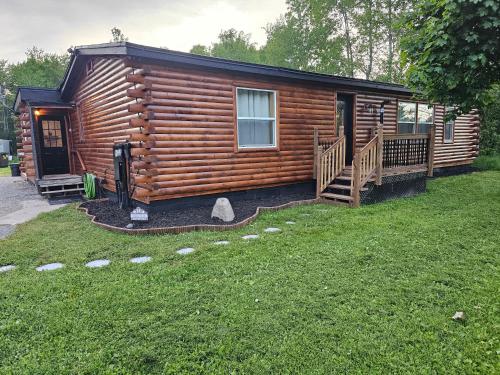 a log cabin with a porch and a deck at Close to Munising, Pictured Rocks, ORV access in Shingleton