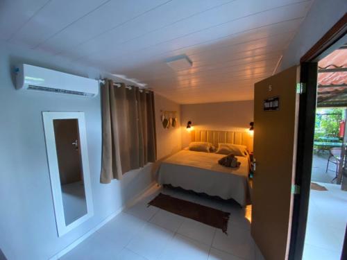 a small bedroom with a bed and a window at Pousada Casa Berna in Fernando de Noronha