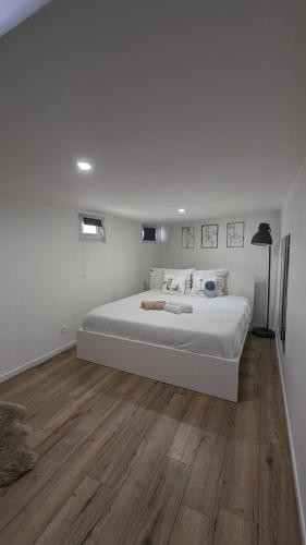 - une chambre blanche avec un grand lit et du parquet dans l'établissement *J'y suis j'y reste* - proche de Paris, à Villejuif